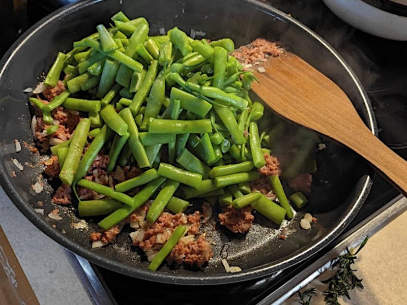 Grüne Bohnen Pfanne mit Bohnenhülsen und Corned Beef