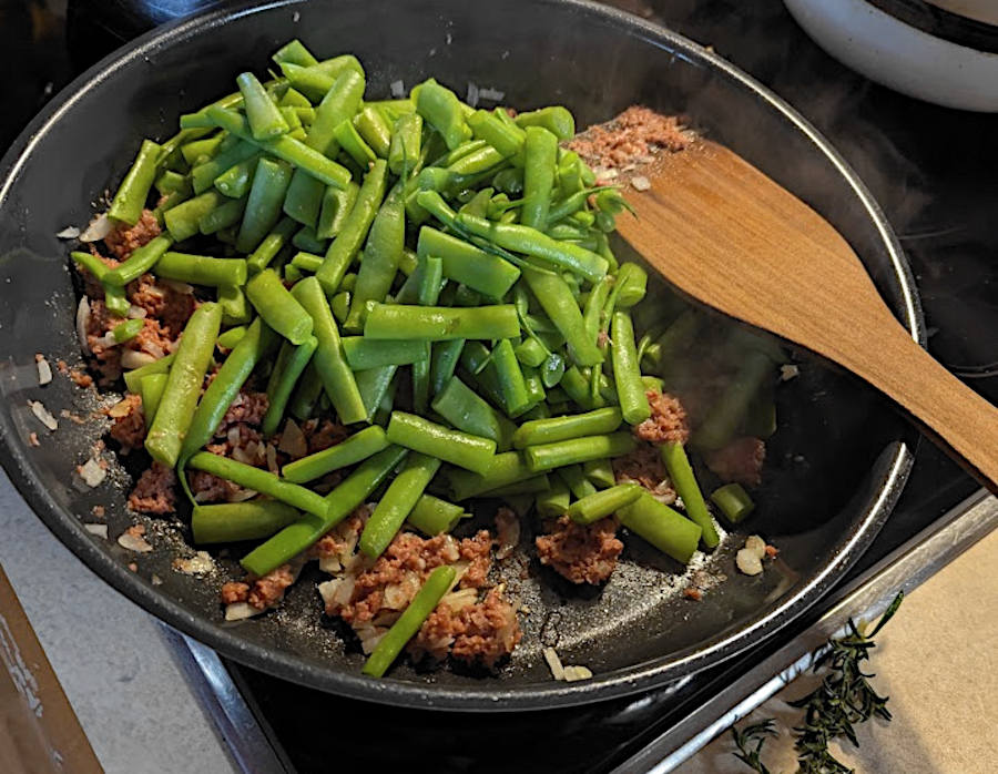 Grüne Bohnen Pfanne mit Bohnenhülsen und Corned Beef