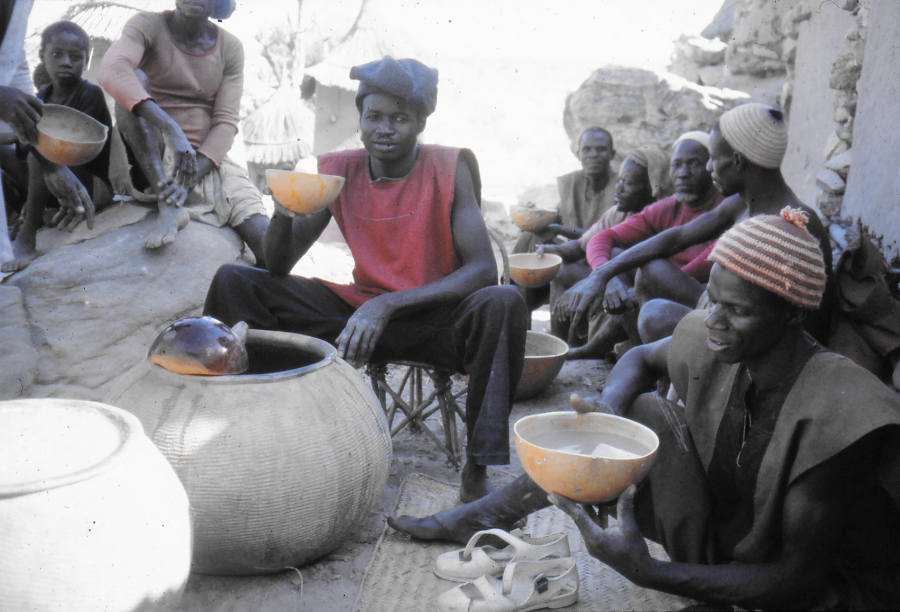 Dogon-Männer, die aus Kürbisschalen Bier trinken