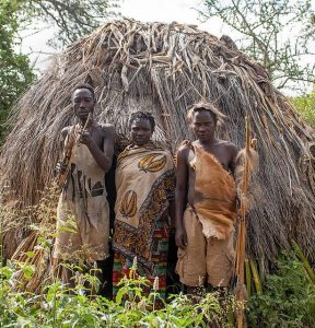 Drei Hadzabe vor ihrer Hütte