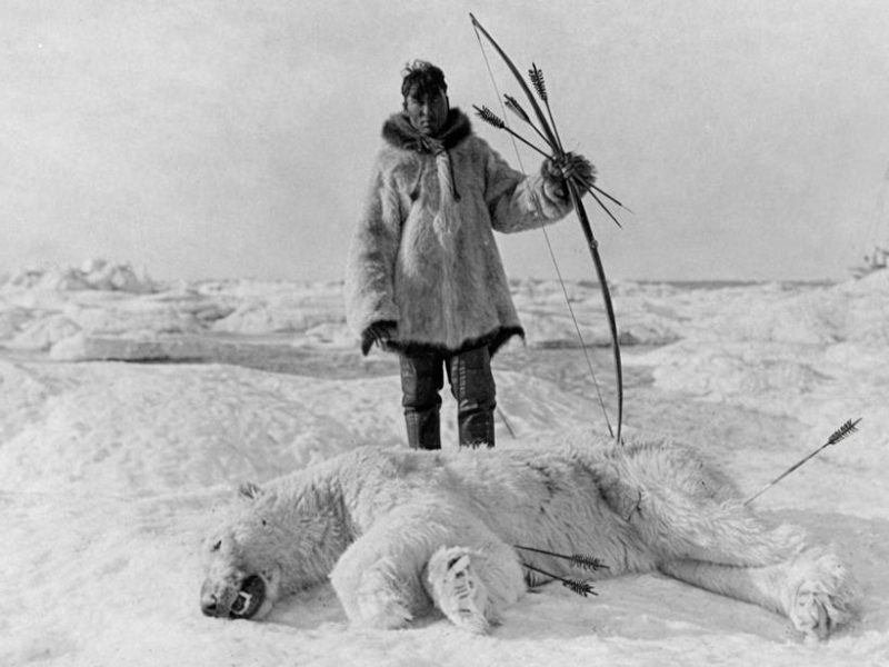 Eskimo-Jäger hinter einem erlegten Eisbären