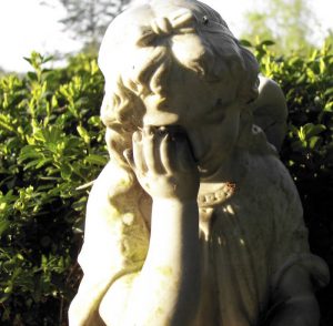 Kleine Plastik eines trauernden Kindes