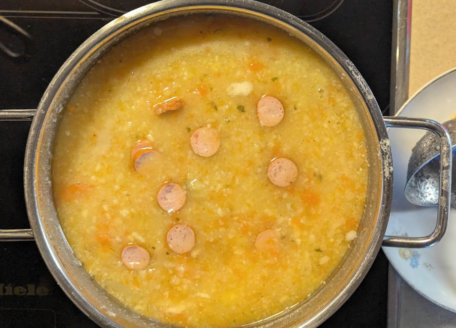 Kartoffelsuppe mit Wurstscheibchen in einem Kochtopf